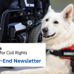 Image depicts a service dog next to a person in a motorized wheelchair.