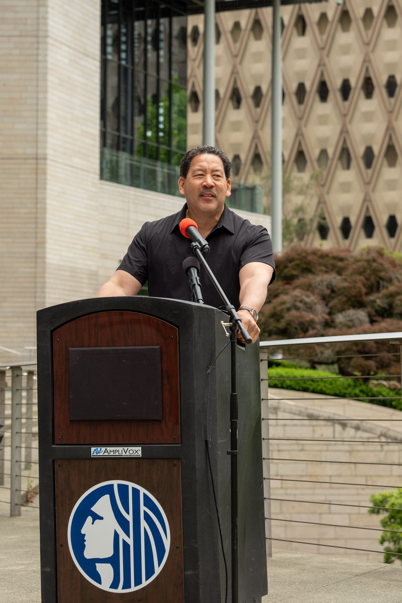 Mayor Bruce Harrell smiles while standing at the lectern.