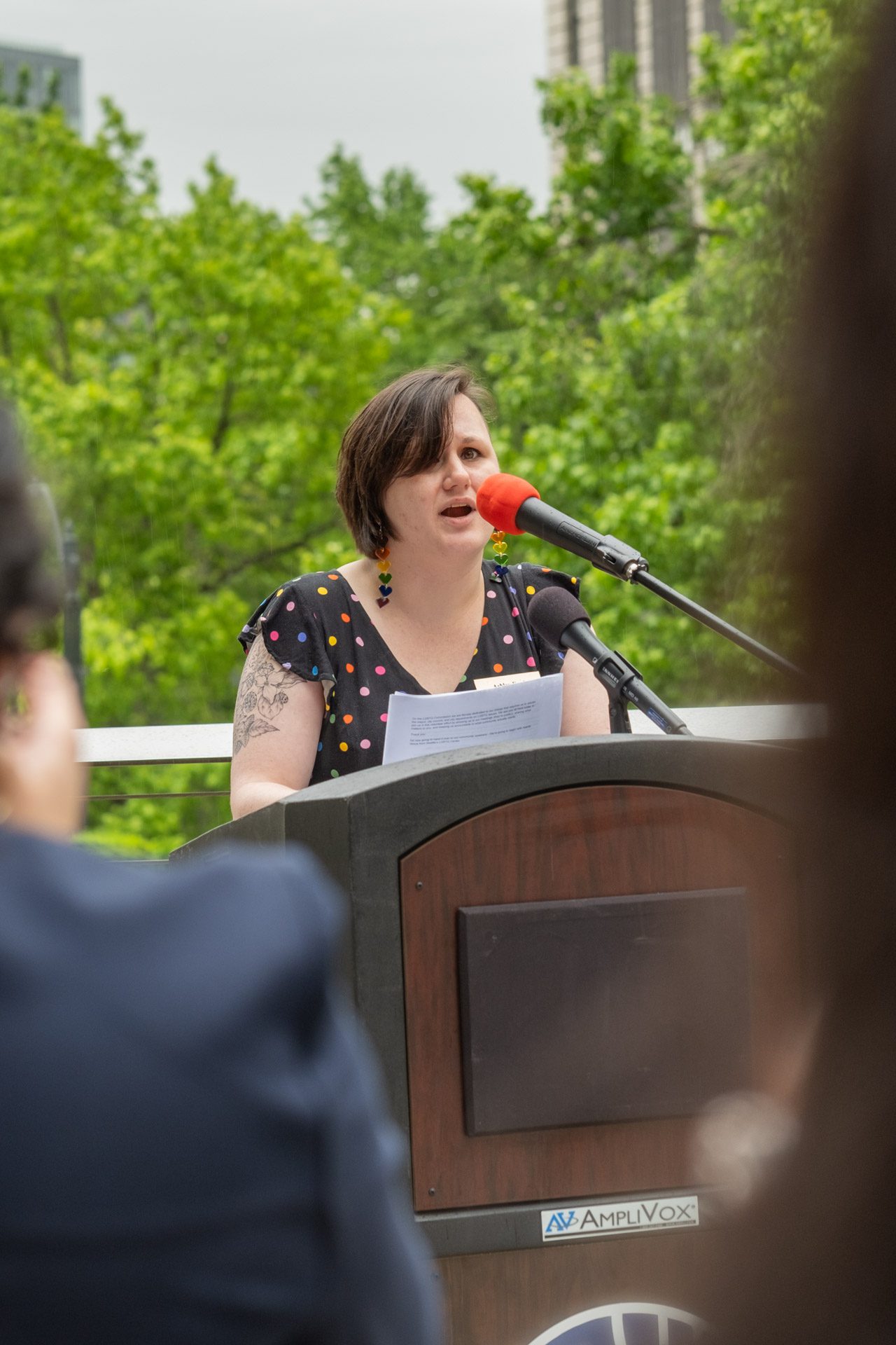 LGBTQ Commissioner, Ashley Ford, speaks into a microphone.