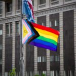 A pride flag flying over Seattle City Hall