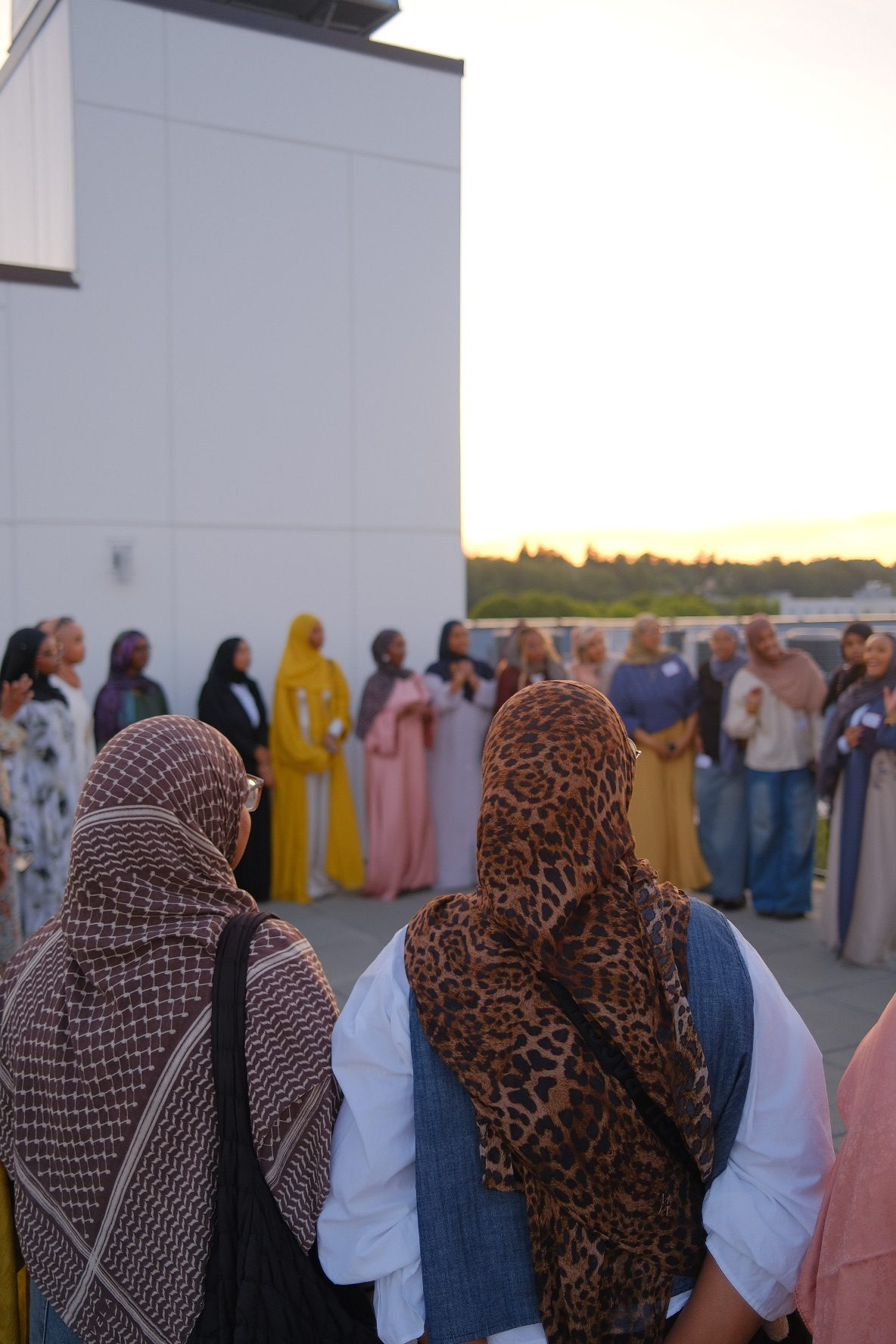 A group of women wearing hijabs gather in a circle. 
